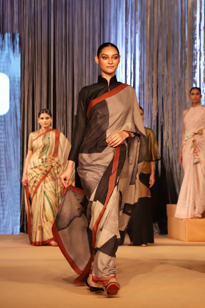 creative Models showcasing elegant traditional Indian sarees on a runway during a fashion show.