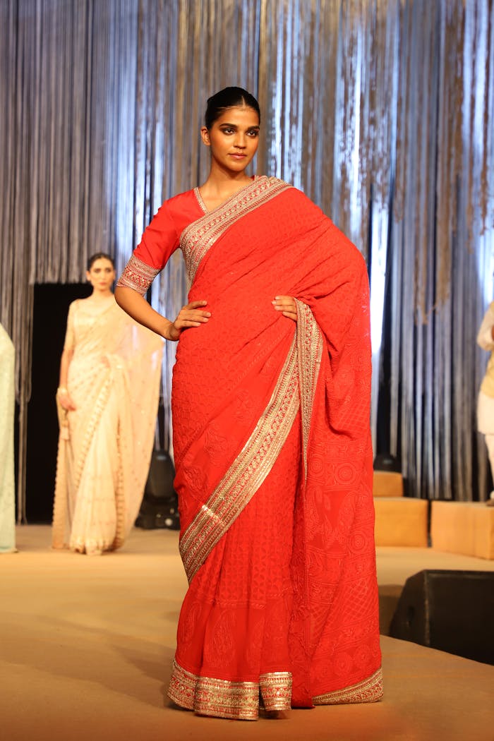 Services-01 Model in red saree with traditional design on the runway in India, showcasing vibrant Indian fashion.